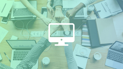 Hands gathered together in the middle of a desk