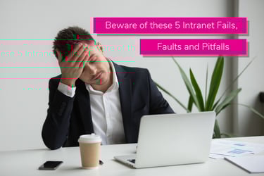 Man sat at a work desk with his head in his hands