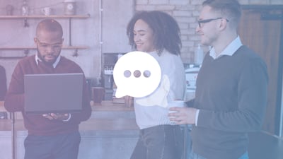 Three employees gathered around in conversation