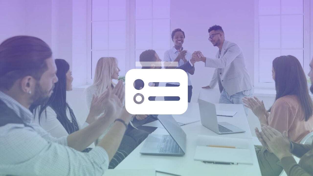 Workers gathered around a meeting room table with laptops
