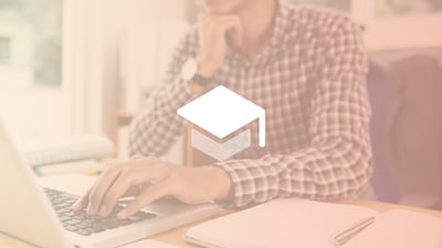 Close up of a man's torso and hands as he types on a laptop