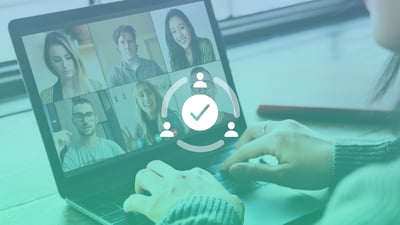 Hands typing on a laptop with the screen displaying a video conference