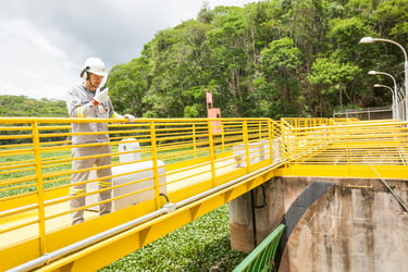 Water utility worker inspecting site on a yellow bridge.