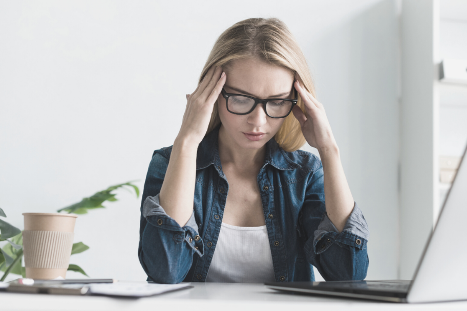 stressed-woman-next-to-coffee-mug-and-laptop